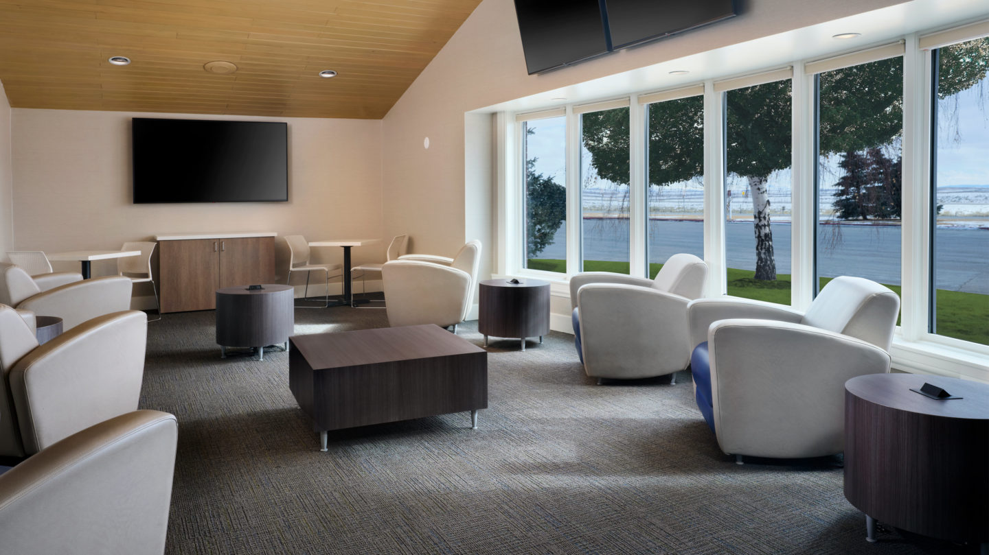 Fuel Center lounge area with seating and televisions on the walls and large windows looking outside